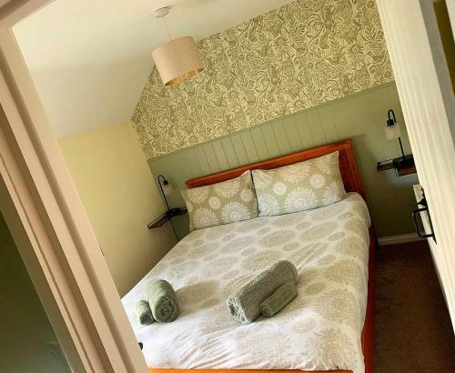 a bedroom with a bed with two pillows on it at CosyCottage, Log Fire&Garden in Mansfield