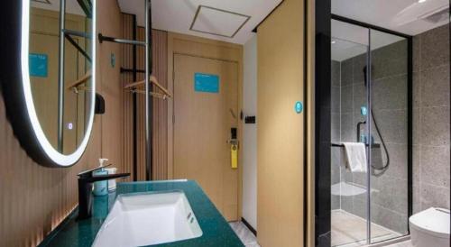 een badkamer met wastafel en douche bij City Comfort Inn Nanning Normal University Mingxiu Metro Station in Nanning