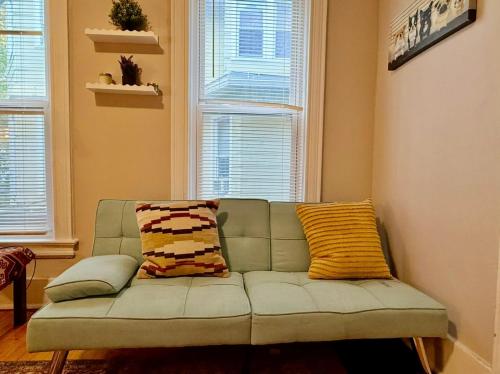 a couch in a living room with two windows at Cozy 1bdrm,highfalls, Wi-fi, Dt, Shopping, Cozy in Rochester