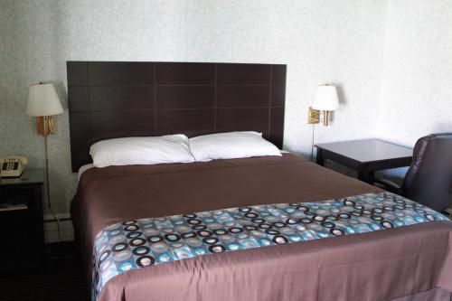 a hotel room with a bed and a chair at Wagon Wheel Inn in Lenox