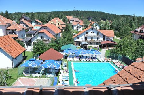 a view of a swimming pool with umbrellas and a resort at Vila Romantika in Zlatibor