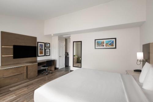 a hotel room with a bed and a flat screen tv at Days Inn by Wyndham Monterey Downtown in Monterey