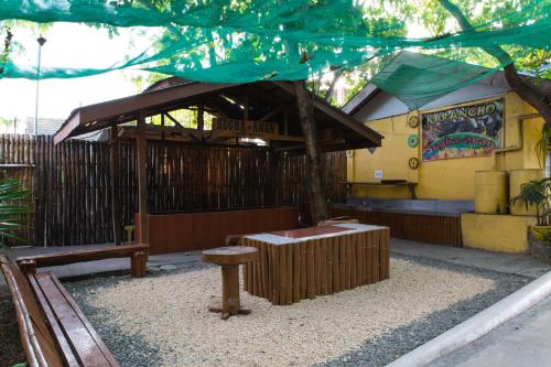 a park with a bench and a building at Karancho Beach House in Mactan