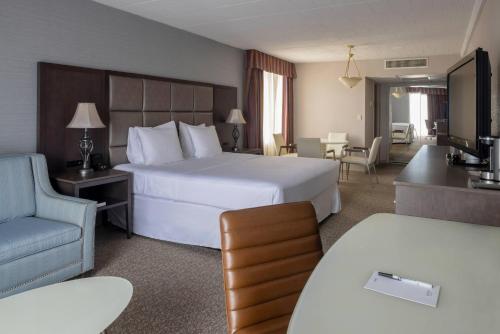 a hotel room with a large bed and a chair at Radisson Hotel Hauppauge-Long Island in Hauppauge