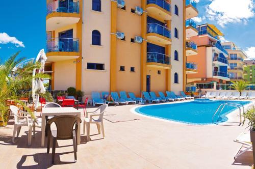 ein Resort mit einem Pool, Stühlen und einem Gebäude in der Unterkunft Hotel Penelope in Primorsko