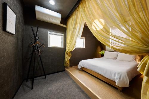 ein Schlafzimmer mit Himmelbett und Fenster in der Unterkunft マイグレ南青山 in Tokio