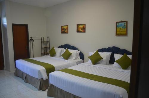 two beds sitting next to each other in a room at Pondok Ganda in Ambarita