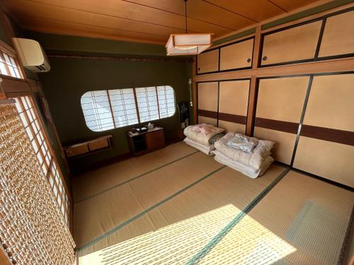 an empty room with a bed and a window at Honjo no Ie in Yurihonjo