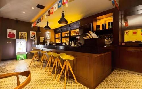 un bar con taburetes amarillos en un restaurante en Tematik Hotel Pluit, en Yakarta