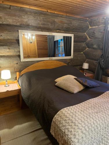 a bedroom with a bed and a wooden wall at Villa Karhuntähti in Luosto