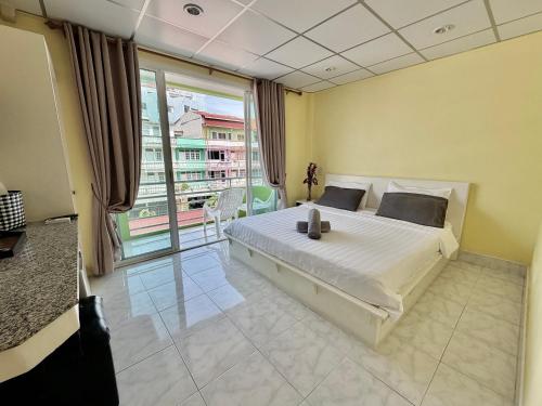 a bedroom with a large bed and a large window at Baan Keang Talay Cha Am in Cha Am