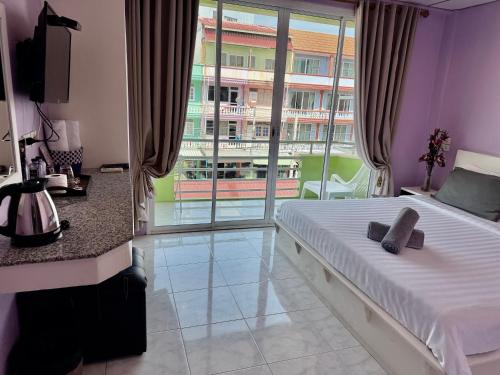 a bedroom with a bed and a large window at Baan Keang Talay Cha Am in Cha Am