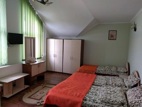 a bedroom with two beds and avertisement at Casa cu pauni in Mărăcineni