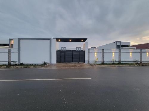 a white building with a gate and a street at MARIGOLD APARTMENTS in Salama Park in Lusaka