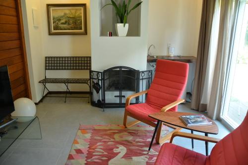 a living room with a red chair and a table at Casa da Ilha do Mel - Pousada de Charme in Ilha do Mel