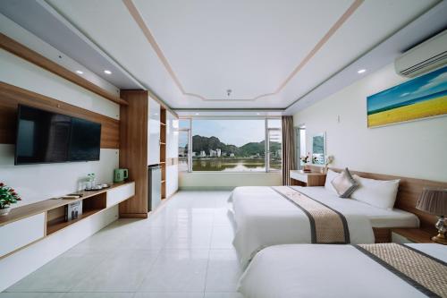 a hotel room with two beds and a television at Seoul Hotel Cat Ba in Cat Ba