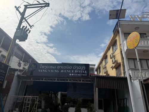 une rue avec une enseigne pour un magasin de musique dans l'établissement Avenue Hotel VangVieng, à Vang Vieng