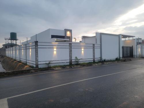 an empty road in front of a white building at MARIGOLD APARTMENTS in Salama Park in Lusaka