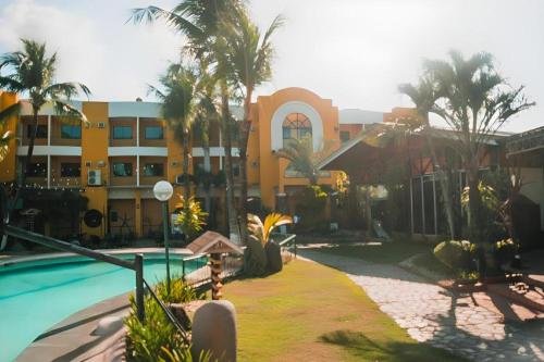 um resort com piscina e palmeiras em Country Village Hotel em Carmen