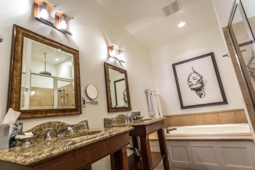 a bathroom with two sinks and a tub and a mirror at The Delafield Hotel in Delafield