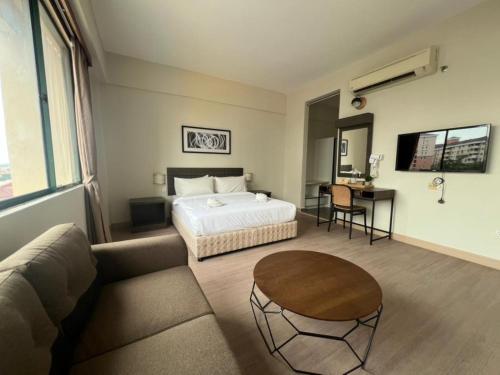 a bedroom with a bed and a couch and a table at Swing & Pillows - I-City, Shah Alam in Klang