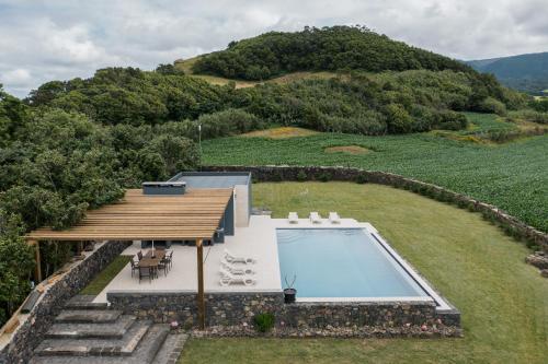 an aerial view of a house with a swimming pool at Herdade do Lameiro - Sea & Mountain Retreat in Ribeira Grande