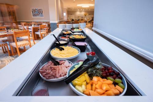 Una línea de buffet con muchos tipos diferentes de comida. en Garden Route Hotel, en Mossel Bay