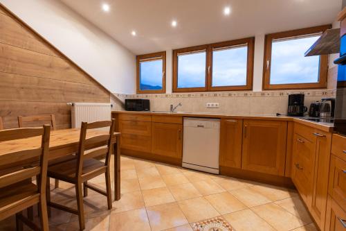 加尔米施-帕滕基兴Höllental heritage House - BergPANORAMA - 5的配有木制橱柜、桌子和椅子的厨房