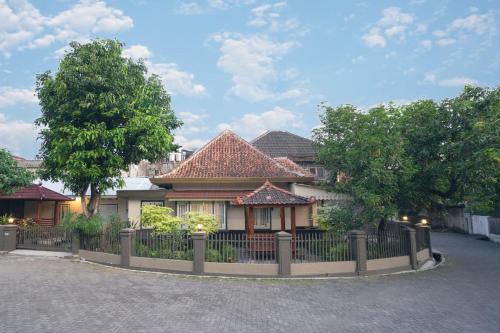 a house with a fence in front of it at Yuwono Hotel & Villa Malioboro in Sentool