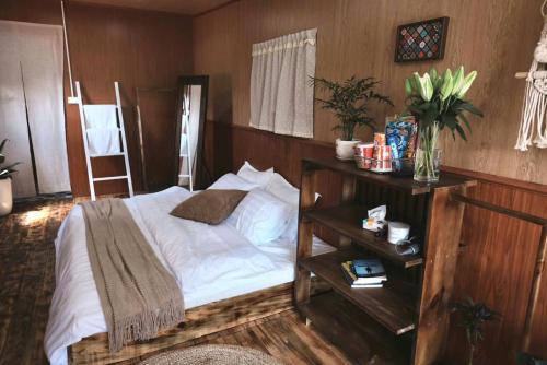 a bedroom with a white bed and a night stand at Xing Retreat & Spa Măng Đen in Kon Plong