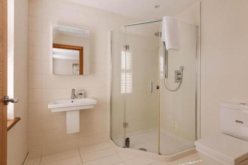 LambegにあるTobela House, Sleeps 10, Ultra Luxuryのガラスのシャワーと洗面台を備えたバスルーム