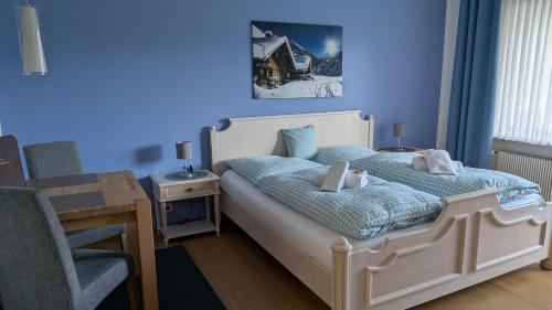 a bedroom with a bed with a blue wall at Ferienwohnung Alpenglück in Bolsterlang Sommerbergbahn kostenlos in Bolsterlang