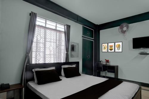 a bedroom with a large bed with a window at Townhouse Howell Crossway Shillong Formerly Laban Guest House in Shillong