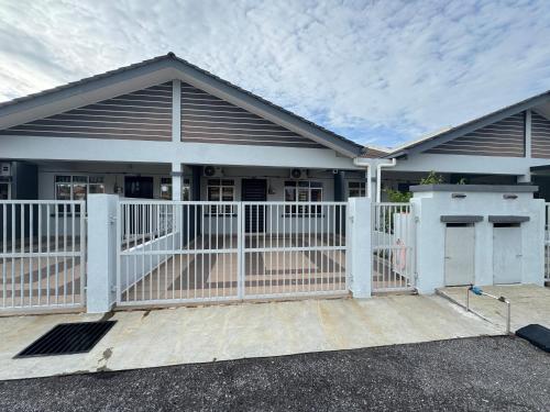 une maison avec une clôture blanche devant elle dans l'établissement Consolatio Near Teluk Senangin, à Lumut