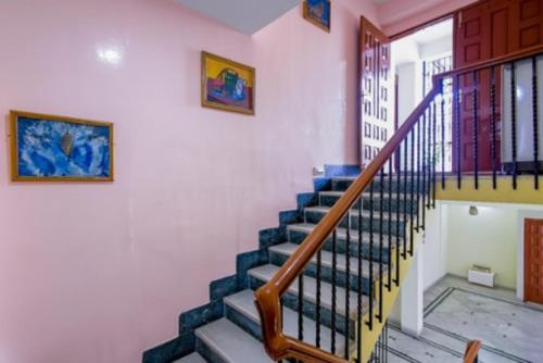 a staircase in a house with blue and yellow walls at PeaceWood in kolkata