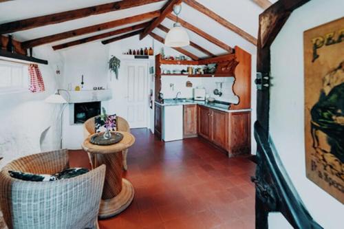 een keuken en woonkamer met een tafel en stoelen bij Finca in El Tanque with a washing machine in Tanque
