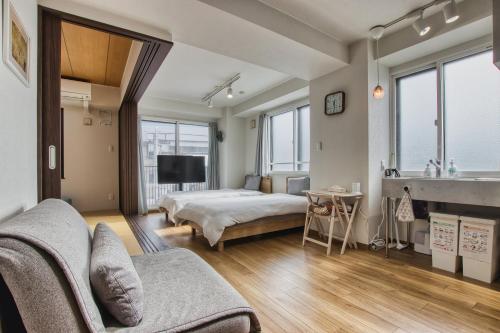 a living room with a bed and a couch at Gamadas BLD in Tokyo