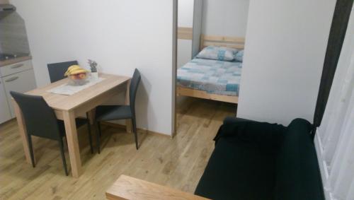 a small room with a table with chairs and a bed at Rooms LU&LA in Velika Gorica