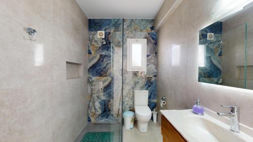 ein Badezimmer mit Toilette, Waschbecken und Spiegel in der Unterkunft Villa Butterfly in Kyrenia