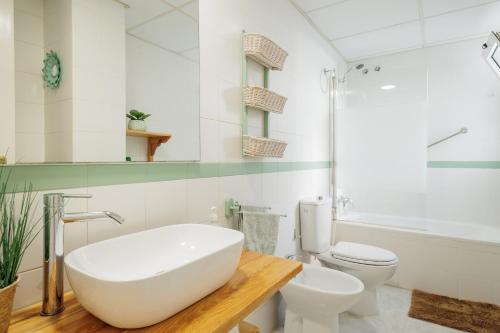 Un baño con bañera blanca y un inodoro. en Bonitas Vistas a Sevilla, en San Juan de Aznalfarache