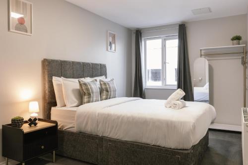 a bedroom with a large bed and a window at Chic 2-Bed, 2 Bath Apt in City Centre Sleeps 6, Free Secure Parking in Belfast