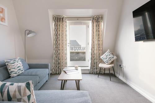 a living room with a couch and a window at Chic 2Bed 2Bath apartments by Luxus in City Centre Free Secure Parking in Belfast