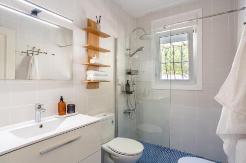 a bathroom with a toilet and a sink and a shower at Lloret · Villa Gamené piscina y mar in Lloret de Mar