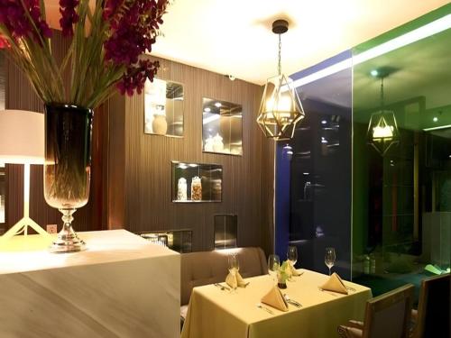 een restaurant met 2 tafels en een vaas met bloemen bij Shenyang Holz Hotel in Shenyang