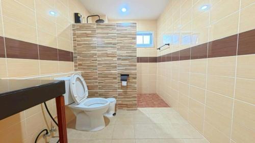 a bathroom with a toilet and a stone wall at Center of old town - 3BR 3BA - Nara Lanna Villa in Chiang Mai