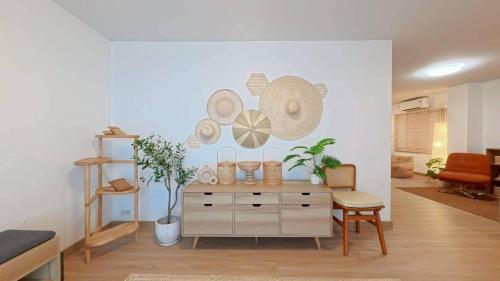 a living room with a dresser with hats on the wall at Center of old town - 3BR 3BA - Nara Lanna Villa in Chiang Mai