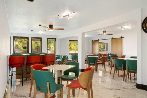 a dining room with tables and chairs and windows at Days Inn by Wyndham Omaha - West Dodge in Omaha