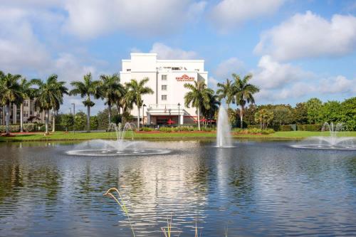 a pond with two fountains in front of a building at Hawthorn Extended Stay by Wyndham West Palm Beach Airport in West Palm Beach