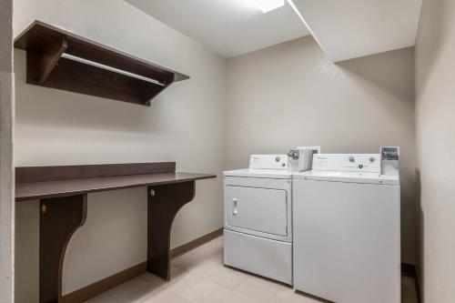 a laundry room with a washing machine and a counter at Microtel Inn & Suites by Wyndham Pearl River/Slidell in Pearl River