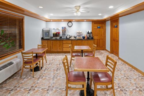 a room with two tables and chairs and a kitchen at Days Inn by Wyndham Slidell in Slidell